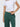 Person wearing green pants and a white cropped top on a light gray background