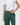 Person wearing green pants and a white cropped top on a light gray background